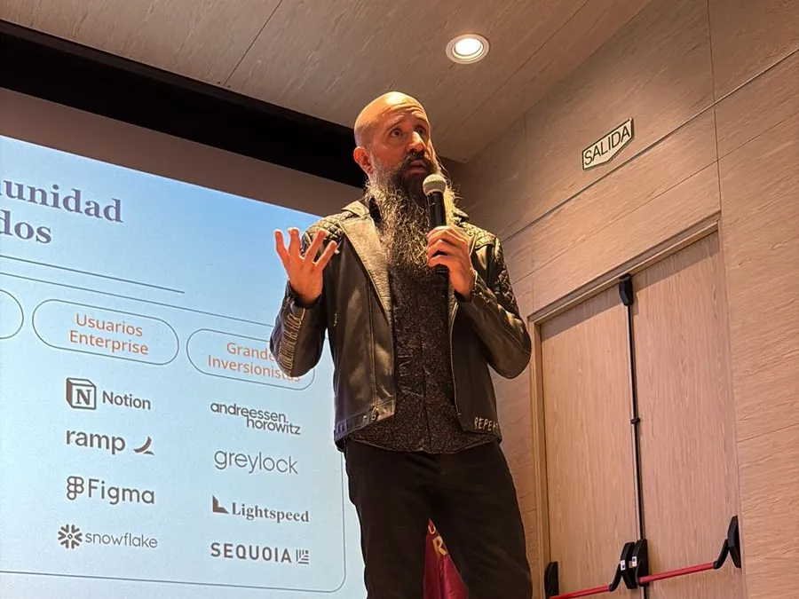 Camilo Ramírez habla en un evento de The AI Collective, frente a la presentación de la comunidad